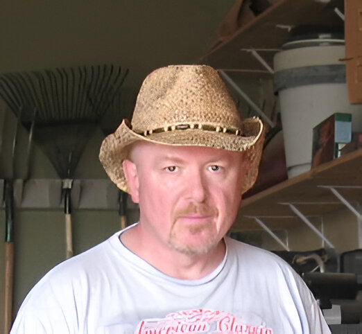 Man in straw hat, garage background.