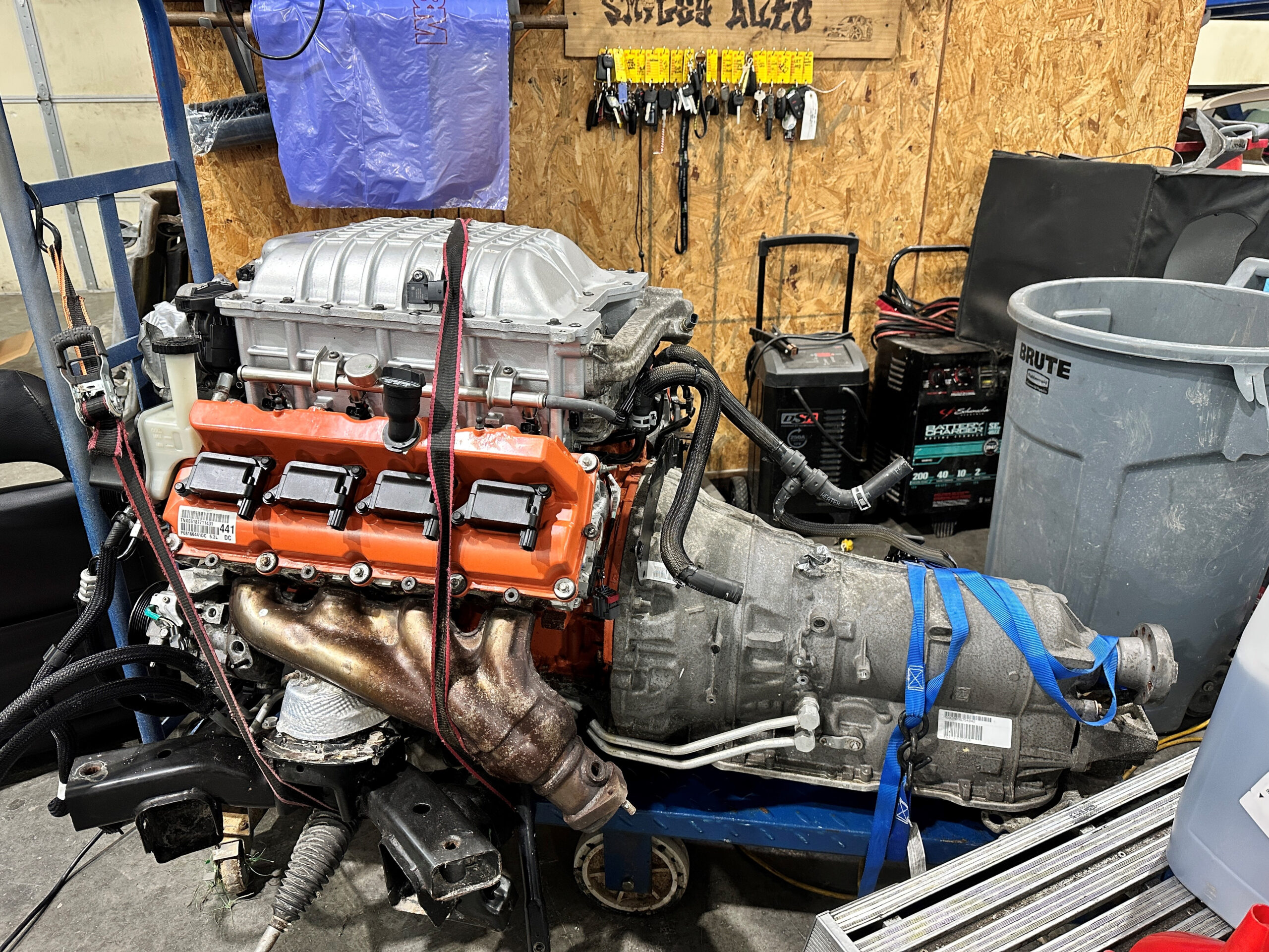 A car engine sitting in the middle of a garage.