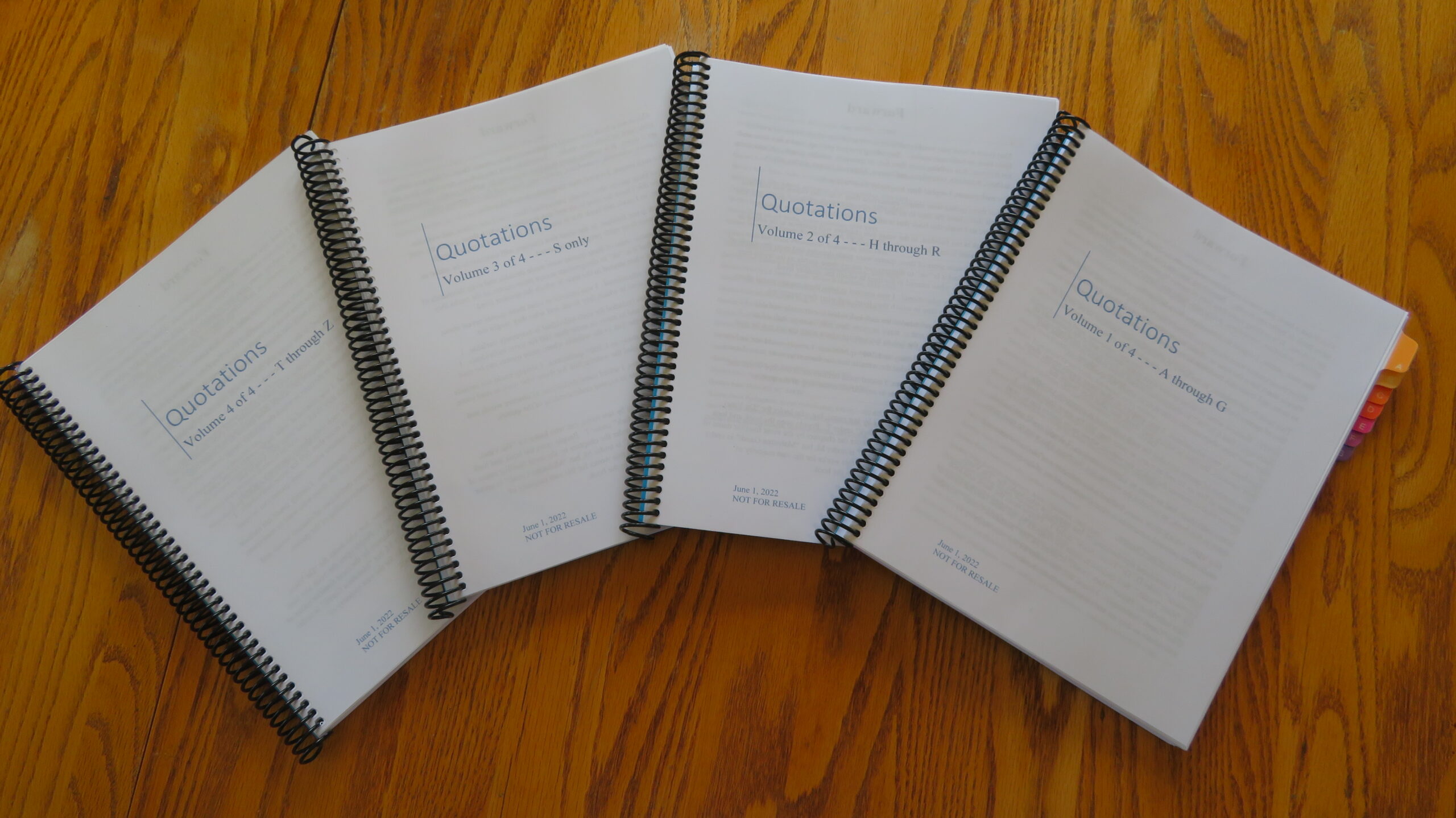 Four spiral bound notebooks on a table.