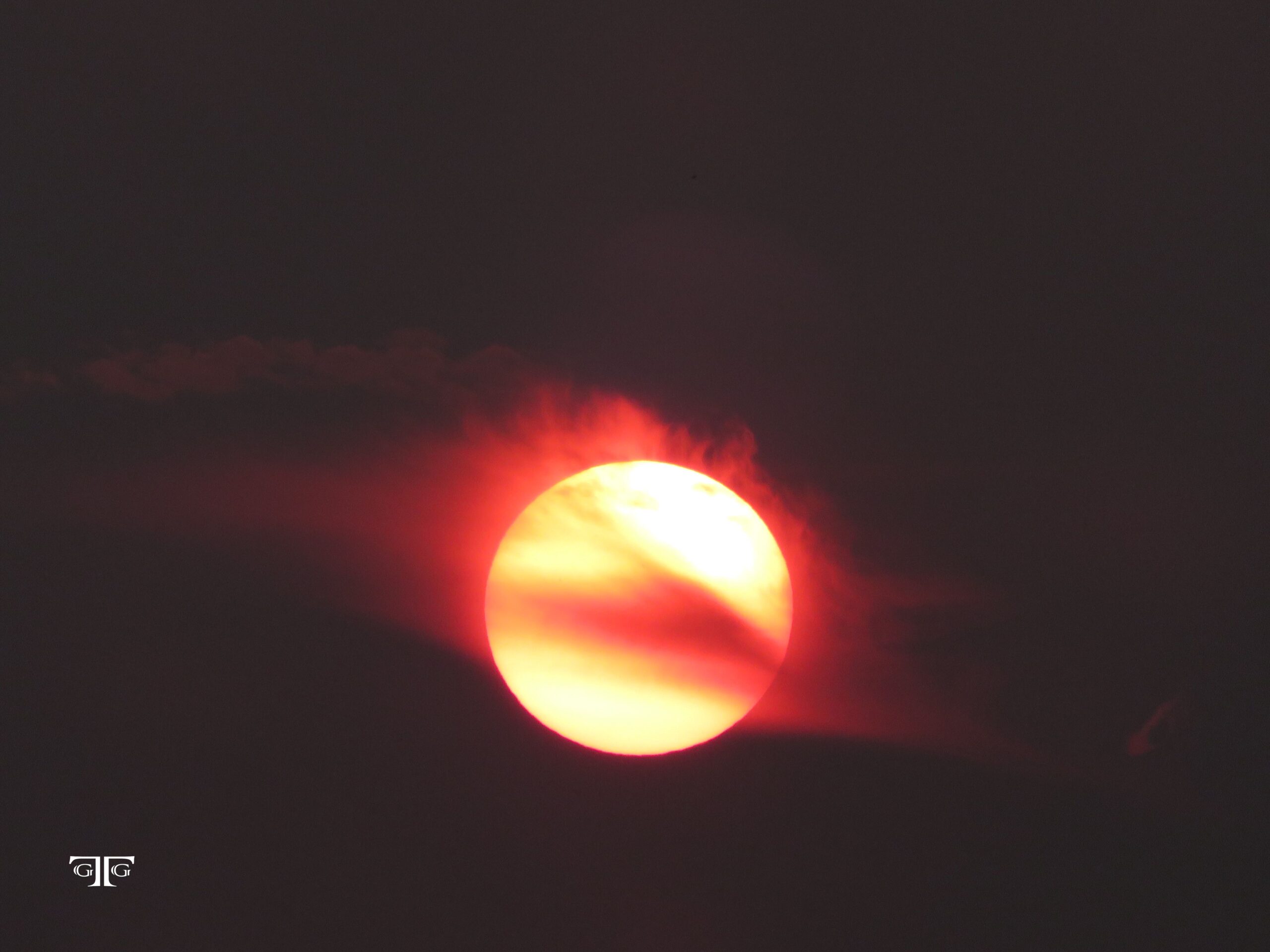 A red sun is seen in the dark sky.