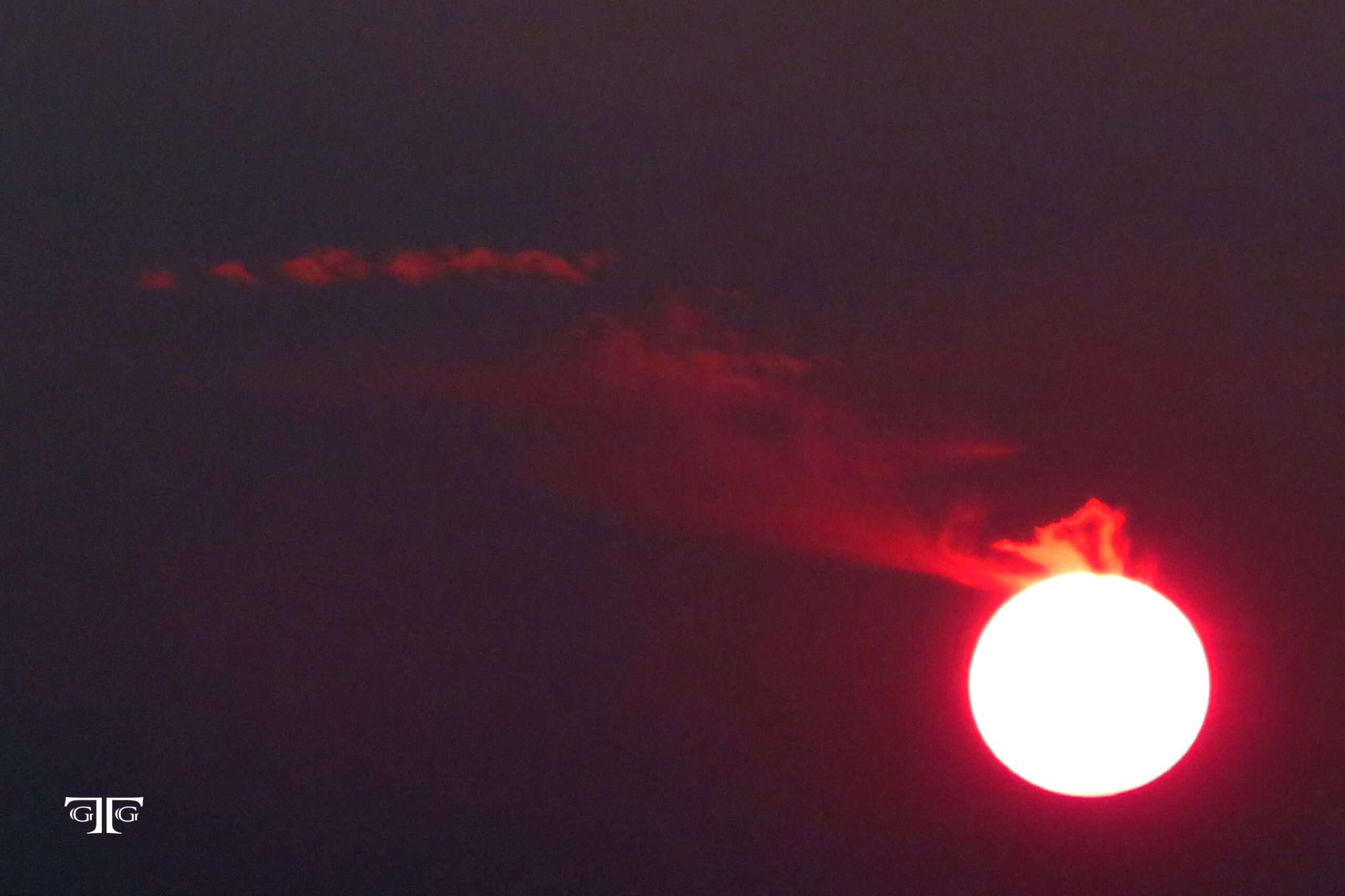 A red sun is seen in the sky at night.