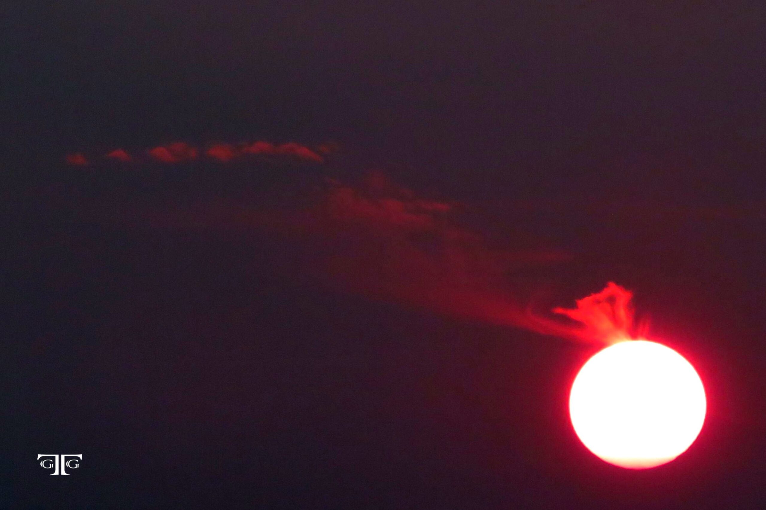 A red sun is seen in the sky at night.