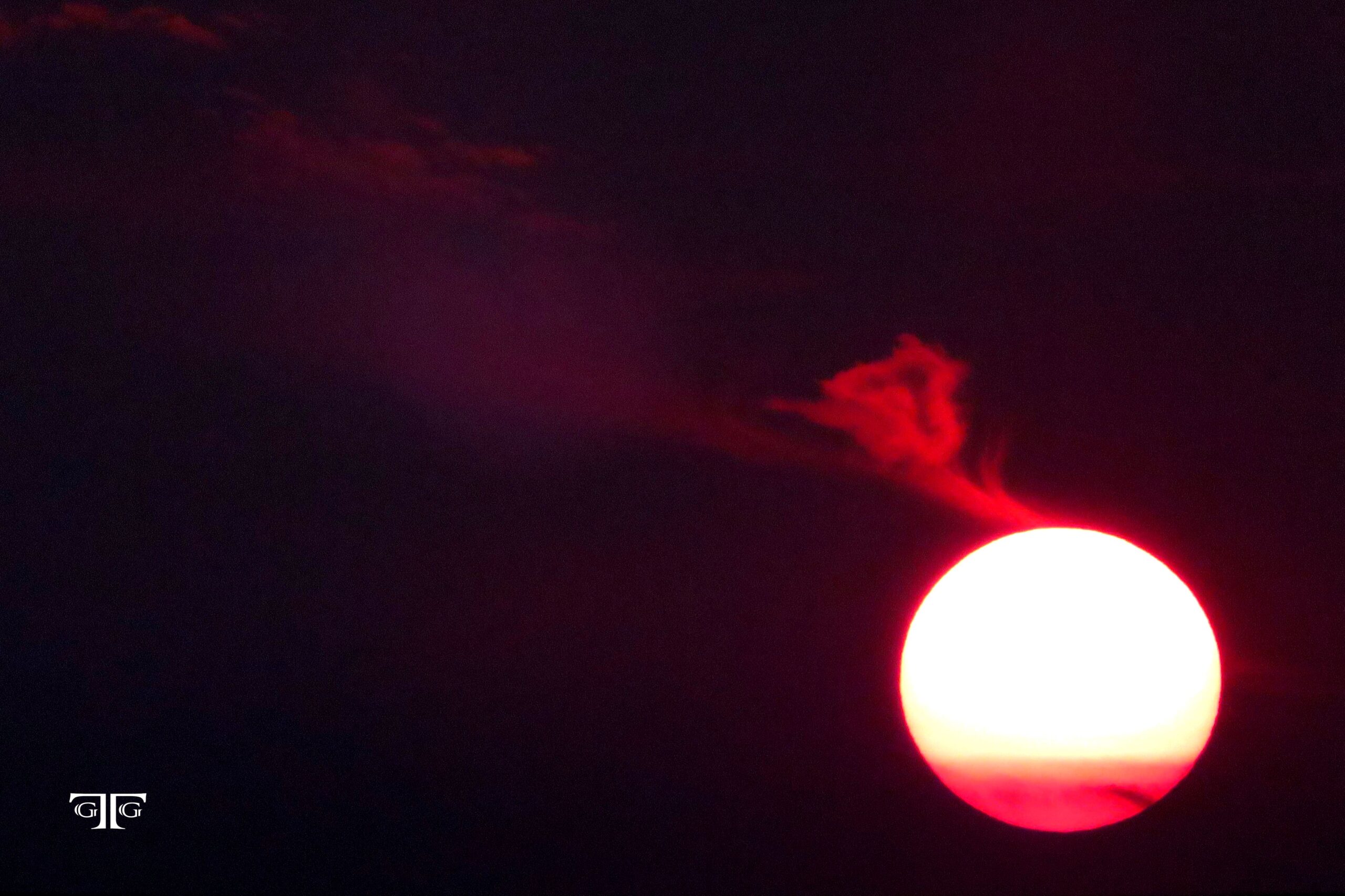 A red sun is seen in the dark sky.