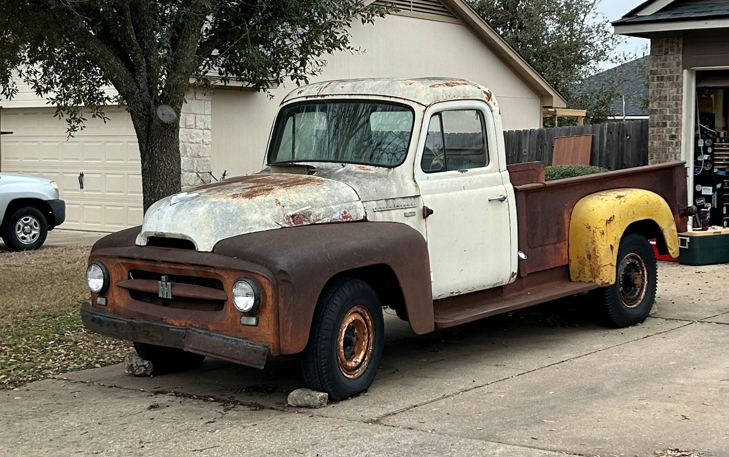 2025-02-09 taken to shop An old truck is parked in front of a house.