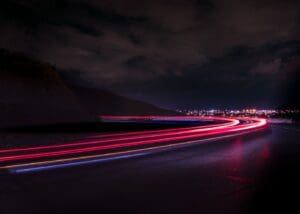 A long exposure photo of the street lights at night.