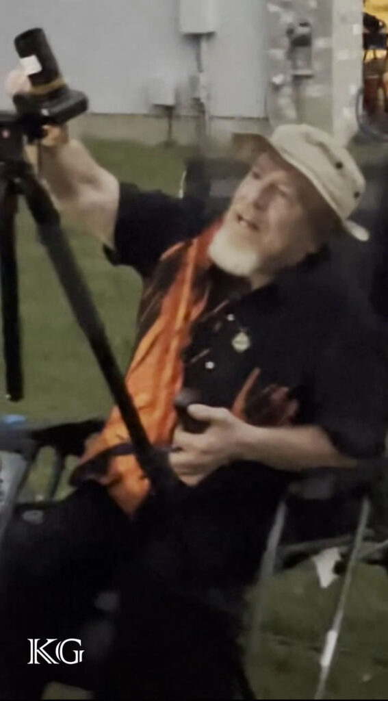 A man sitting in a chair holding a camera.