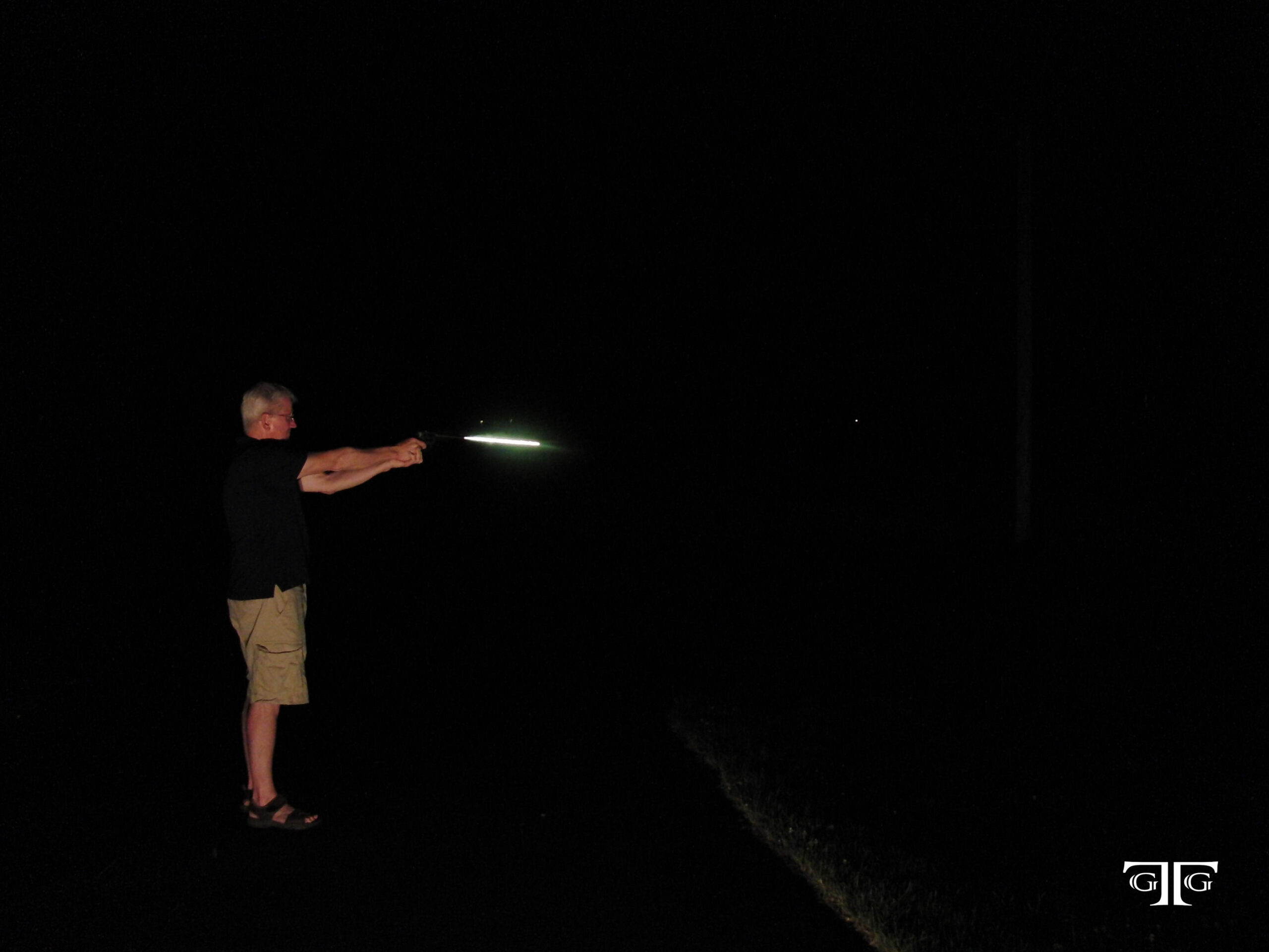 CIMG6539 with GTG logo A man is playing frisbee in the dark.