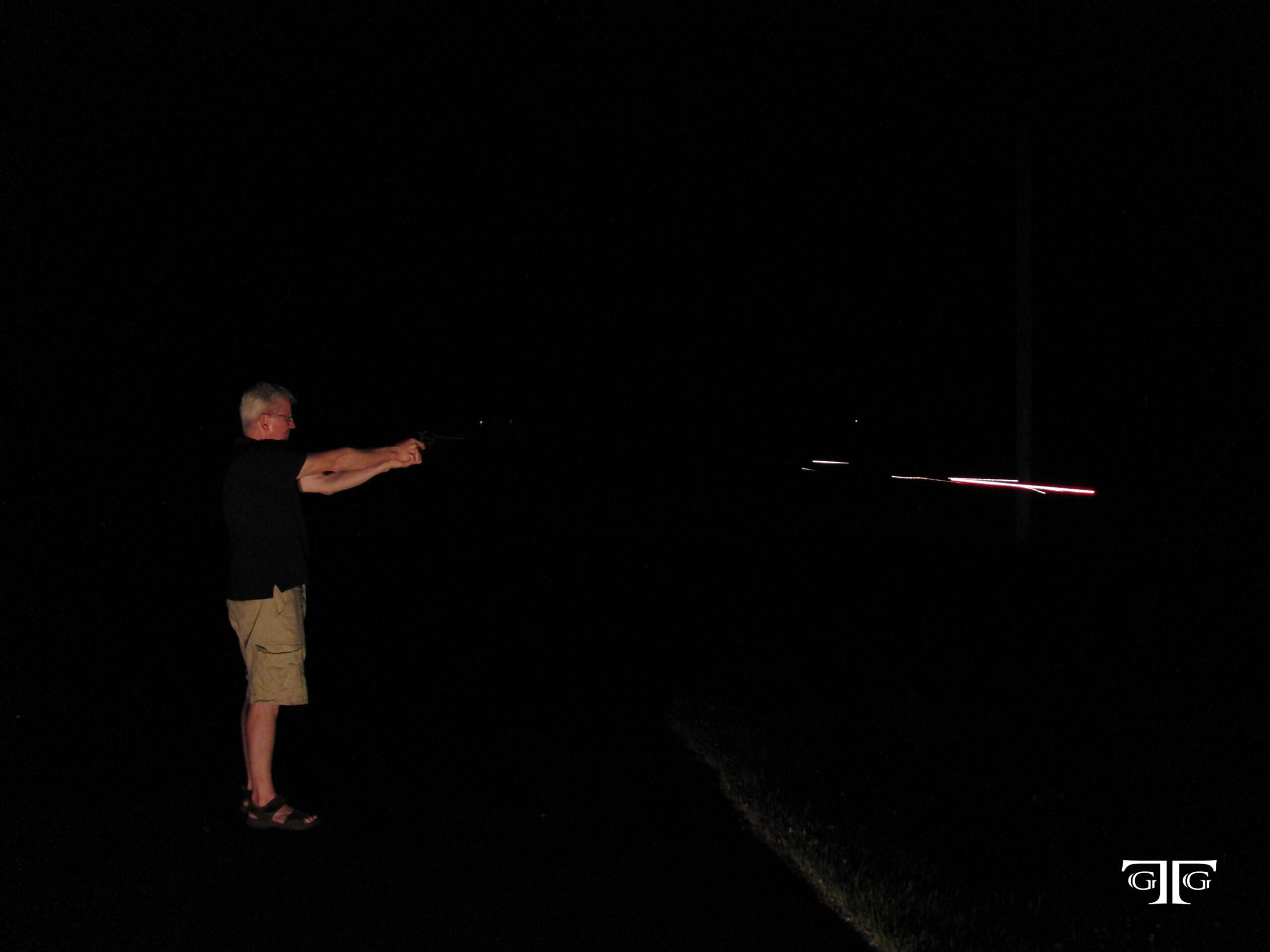 CIMG6542 with GTG logo A man standing in the dark holding onto something