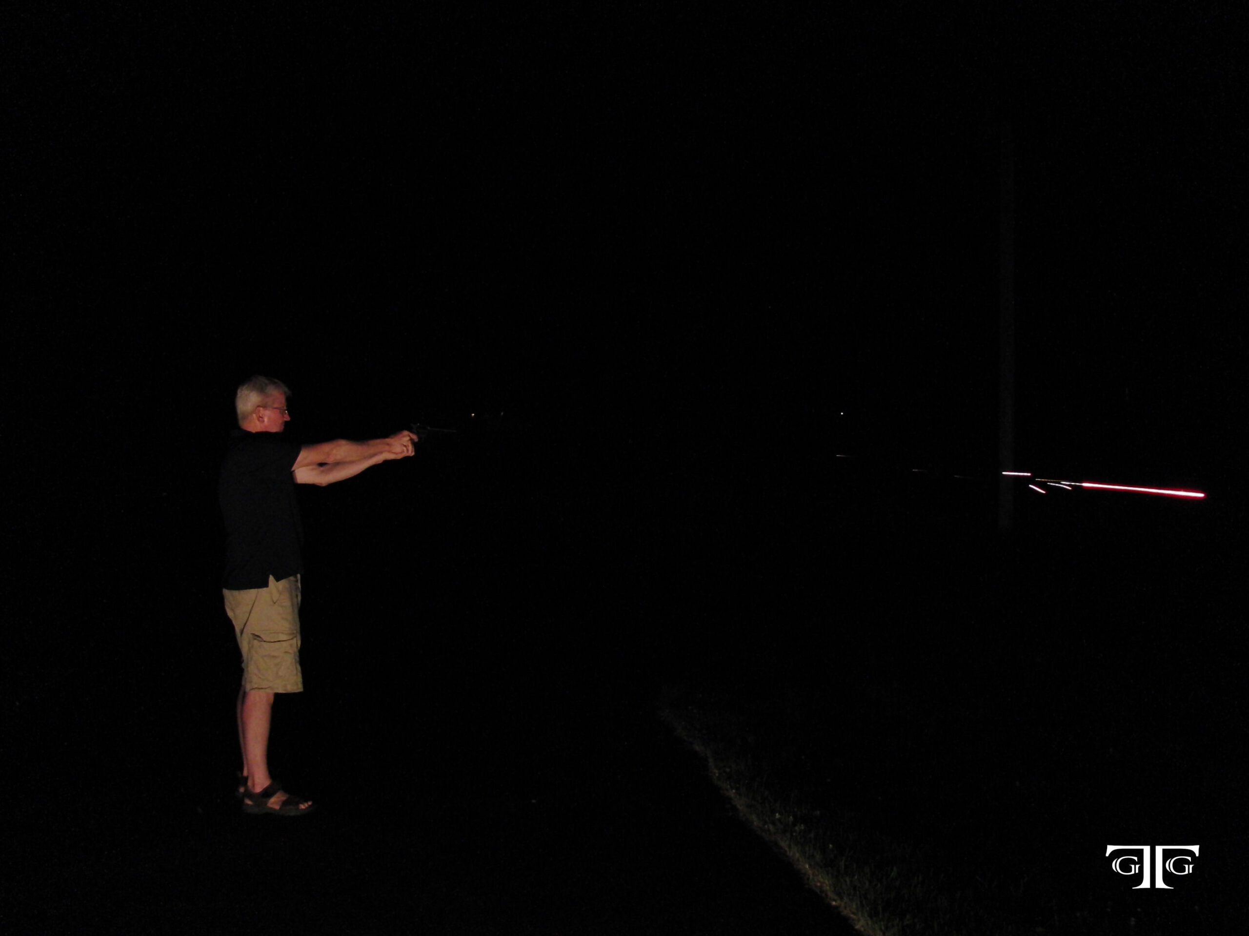CIMG6543 with GTG logo A man standing in the dark holding something.