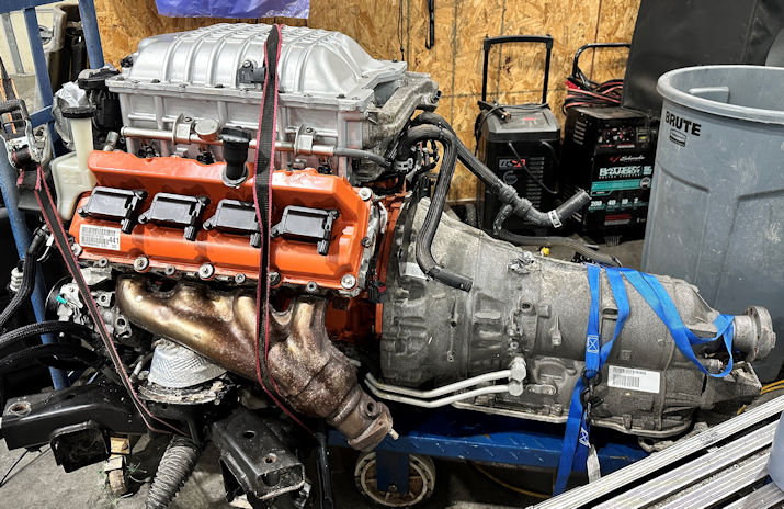 Hemi Hellcat (1) A car engine is being worked on in the shop.