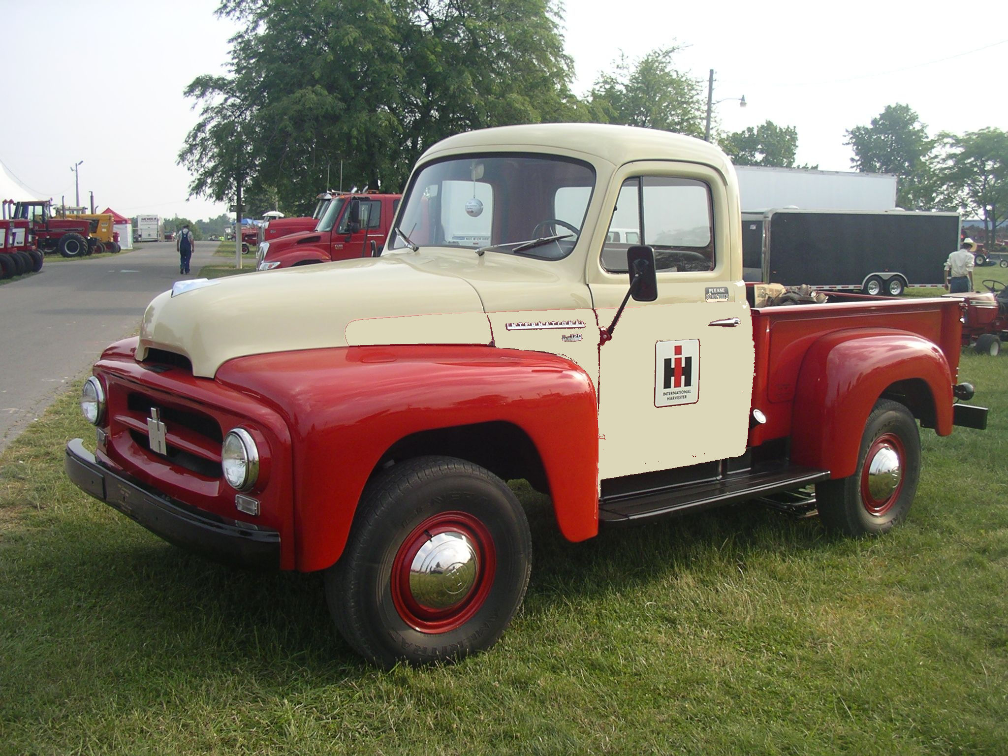 orig colors - patched-a896879 A red and white truck parked in the grass.