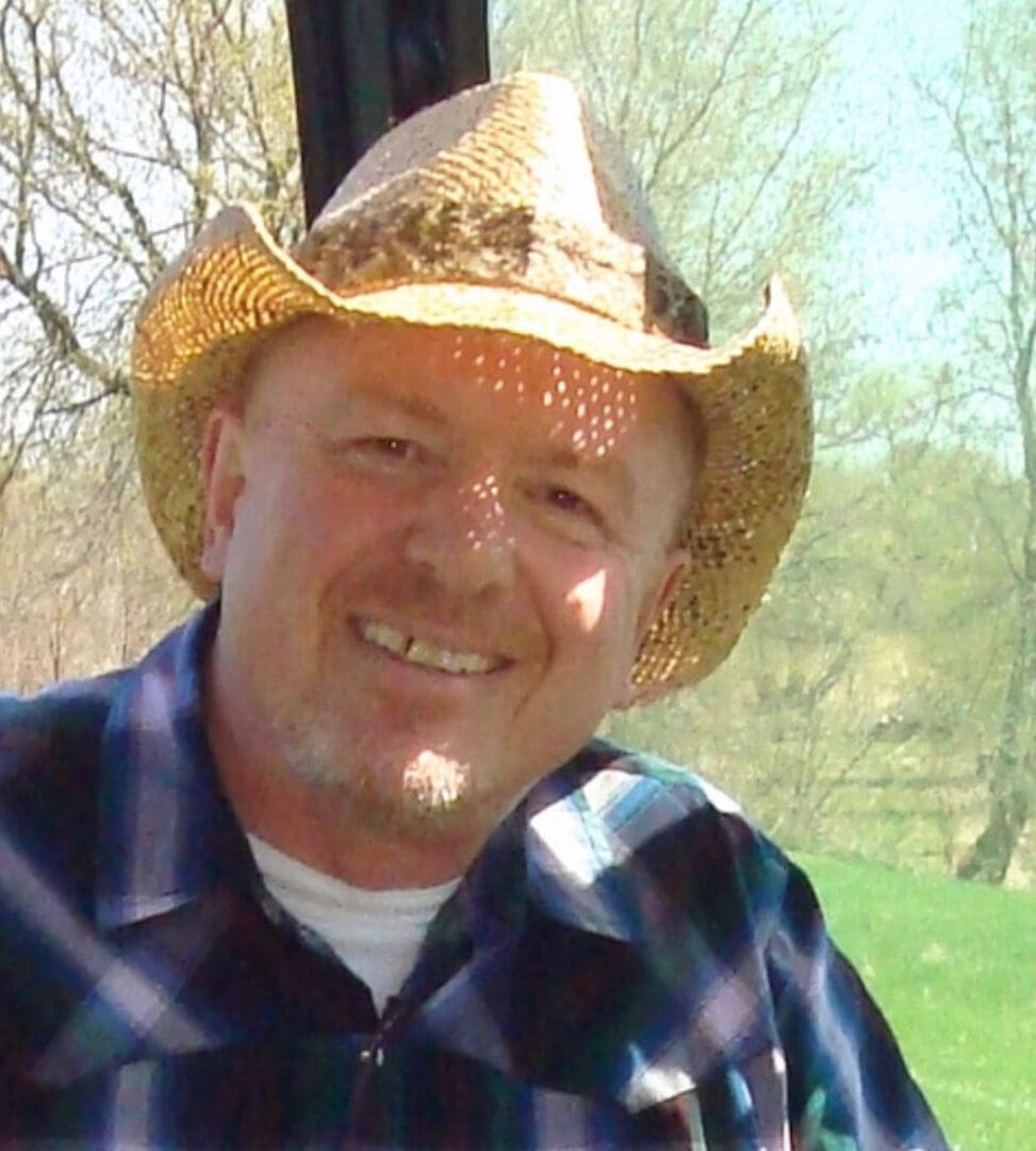 Smiling man wearing hat outdoors.